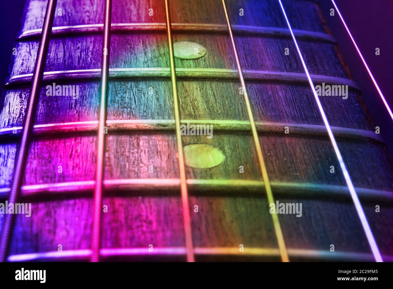 An abstract background of a guitar fretboard and strings in colorful lights Stock Photo Alamy