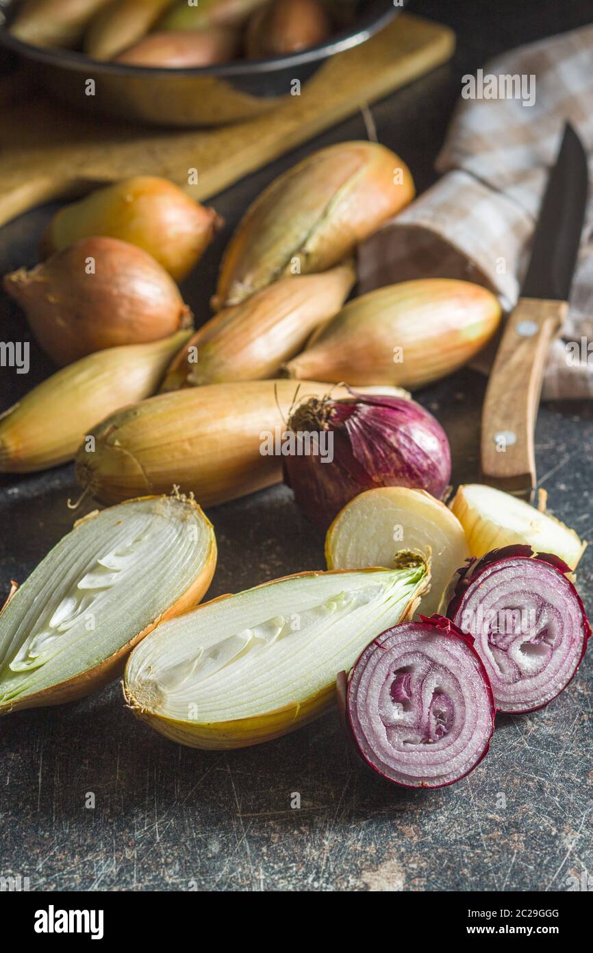 Halved fresh bulbs on old kitchen table. Stock Photo