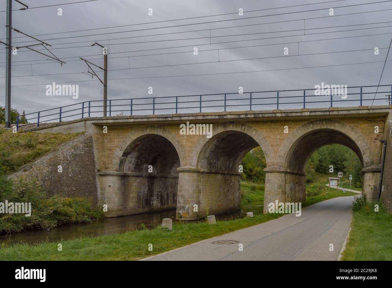 Railway bridge with three arches, two for the river of the tone and one for the tarmaker road in the city of Virton in the province of Luxembourg in B Stock Photo