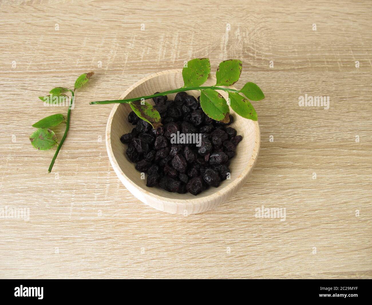 Dried blueberries in a wooden bowl Stock Photo