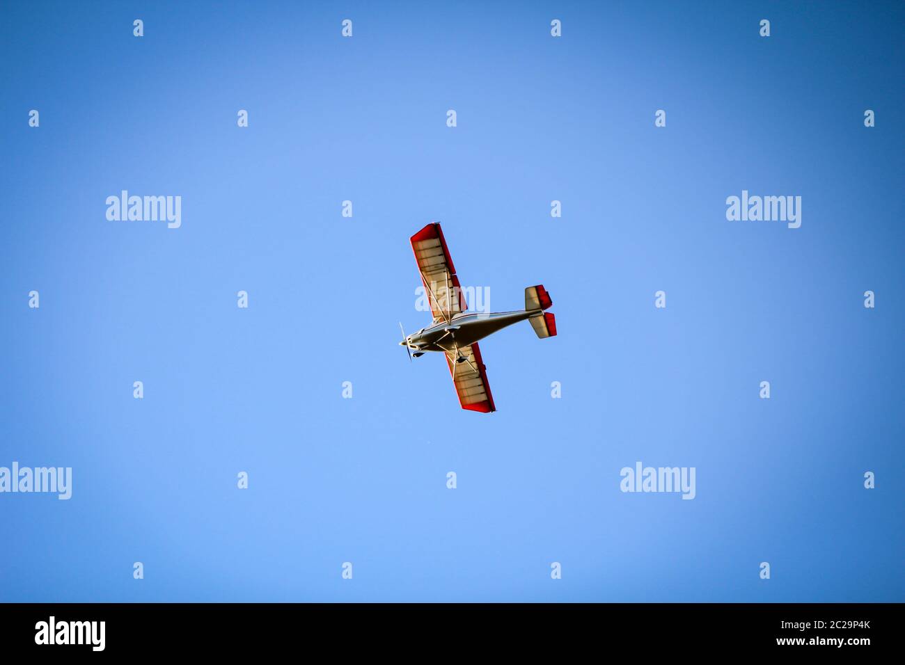 a small airplane in the blue sky Stock Photo