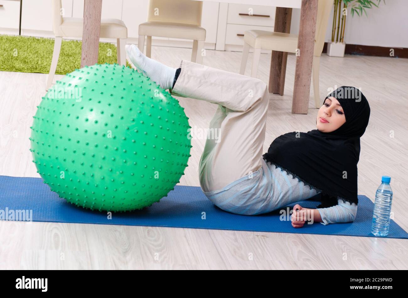 Young woman in hijab doing exercises at home Stock Photo - Alamy