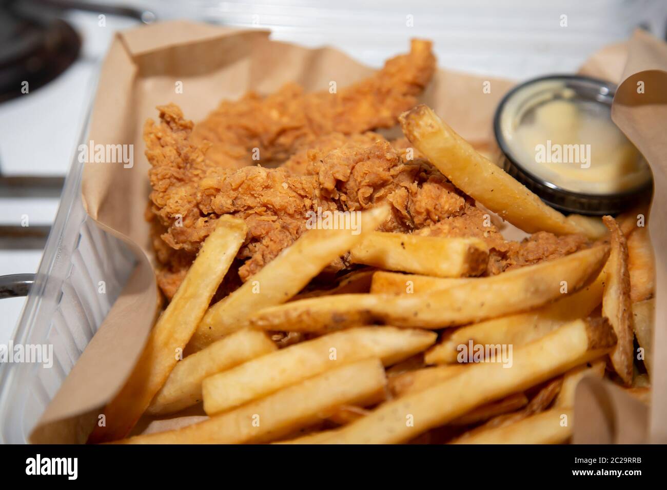 Fried chicken strip basket with french fries and dipping sauce Stock