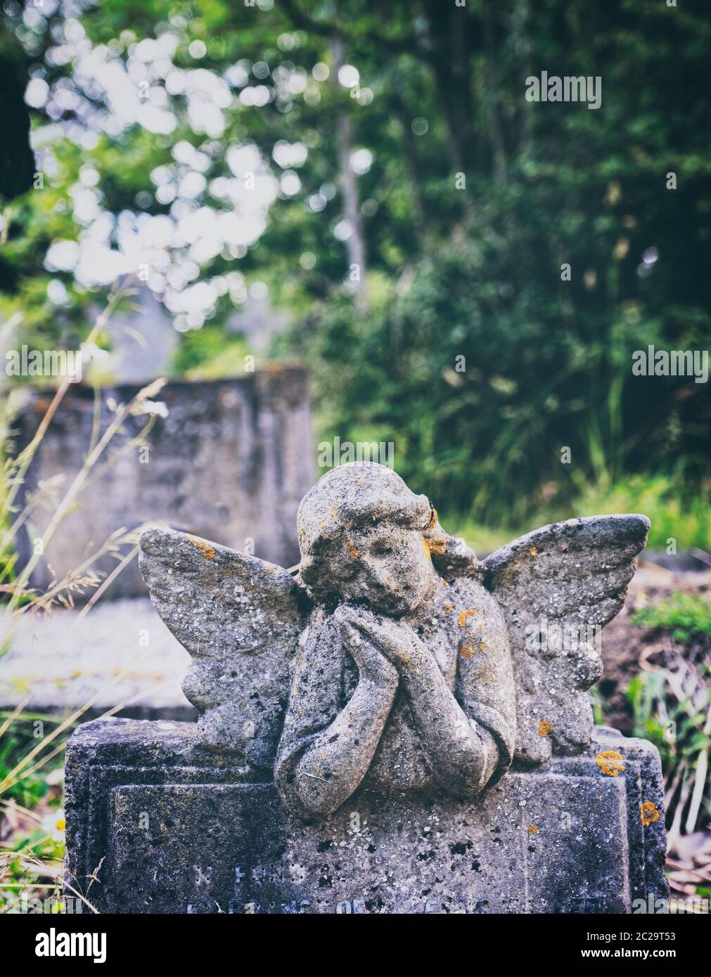 Middle Claydon gothic gatehouse and cemetery carved angel headstone on a childs grave. Stock Photo