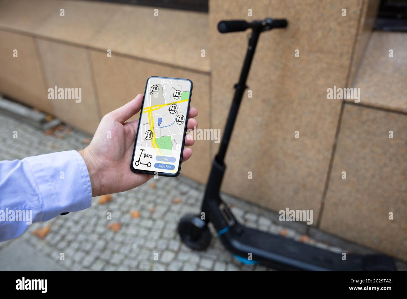 Young Man Using App To Rent Electric Scooter Stock Photo