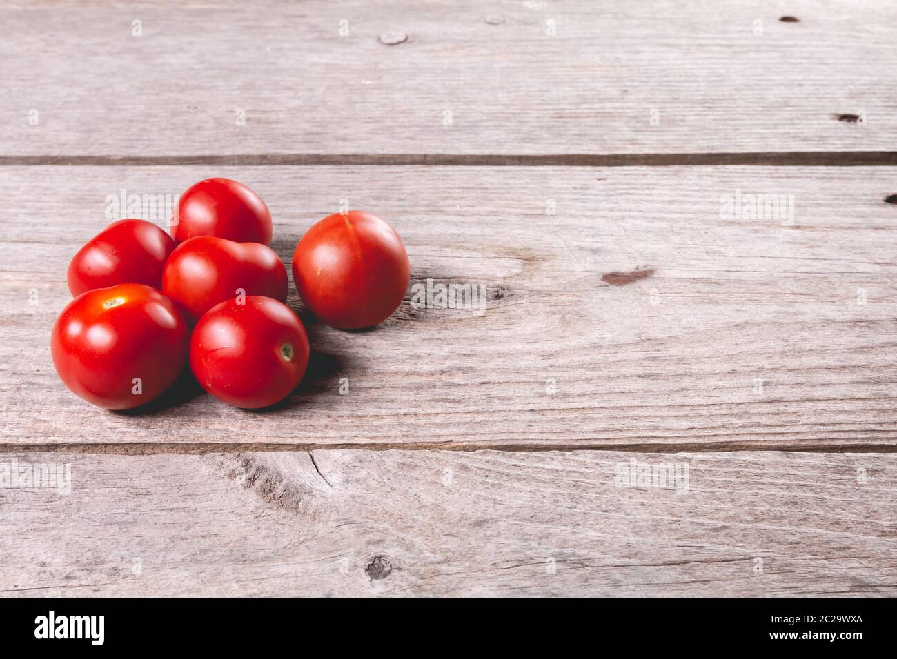 ripe tomatoes on wooden board background in studio Stock Photo - Alamy