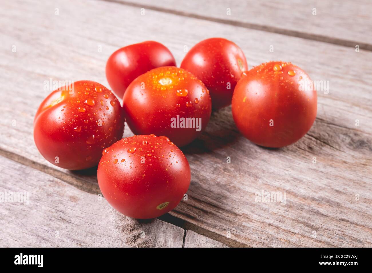 ripe tomatoes on wooden board background in studio Stock Photo - Alamy