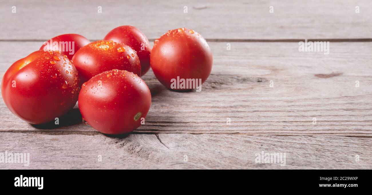 ripe tomatoes on wooden board background in studio Stock Photo - Alamy