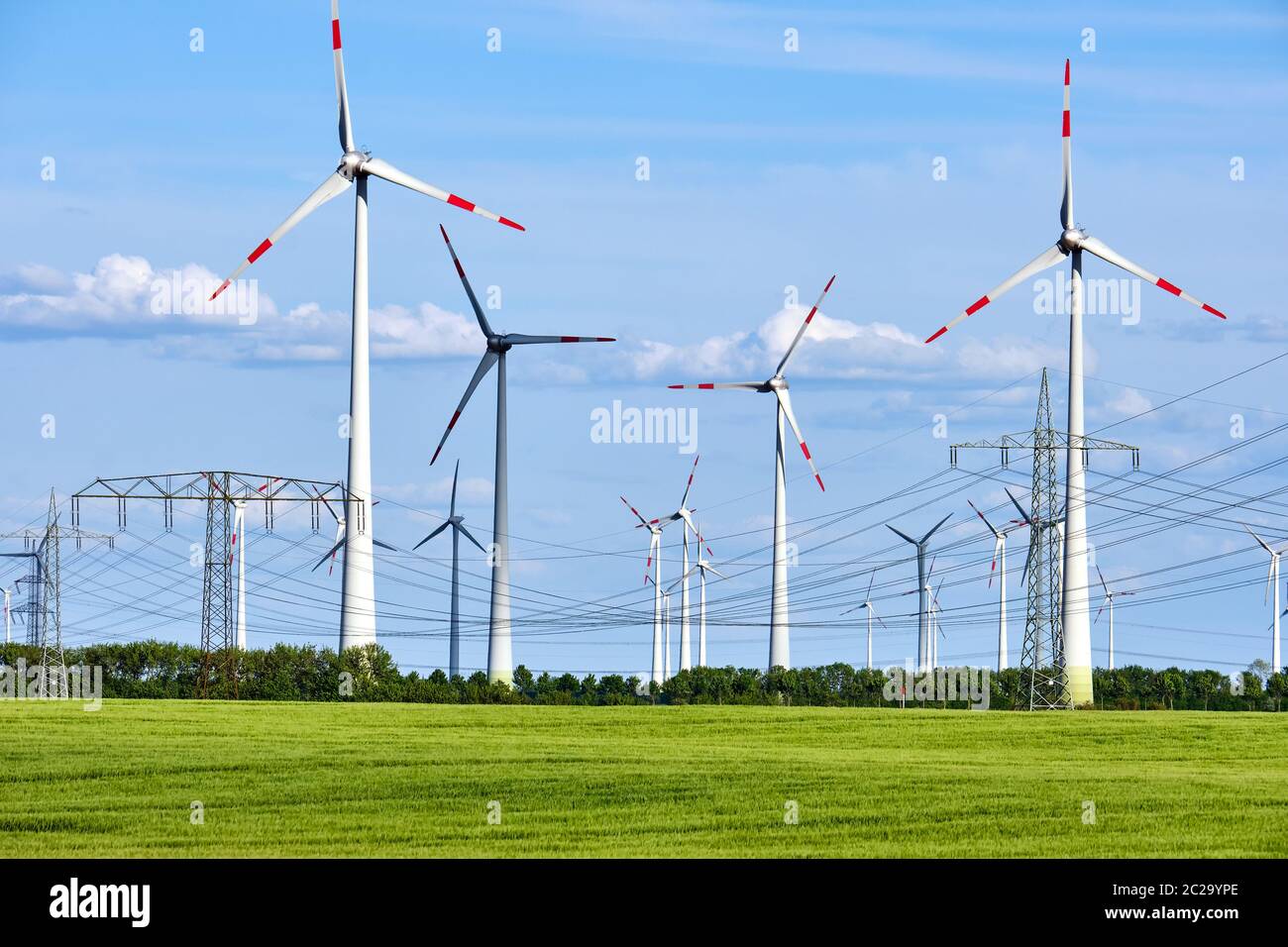 Wind power plants and overhead power lines seen in Germany Stock Photo