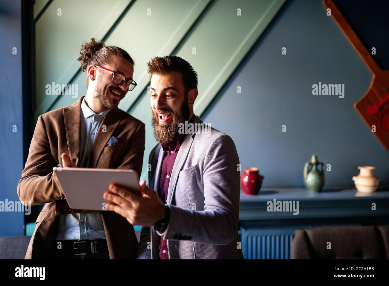 Sharing fresh ideas. Group of young business people in smart casual wear talking and smiling Stock Photo