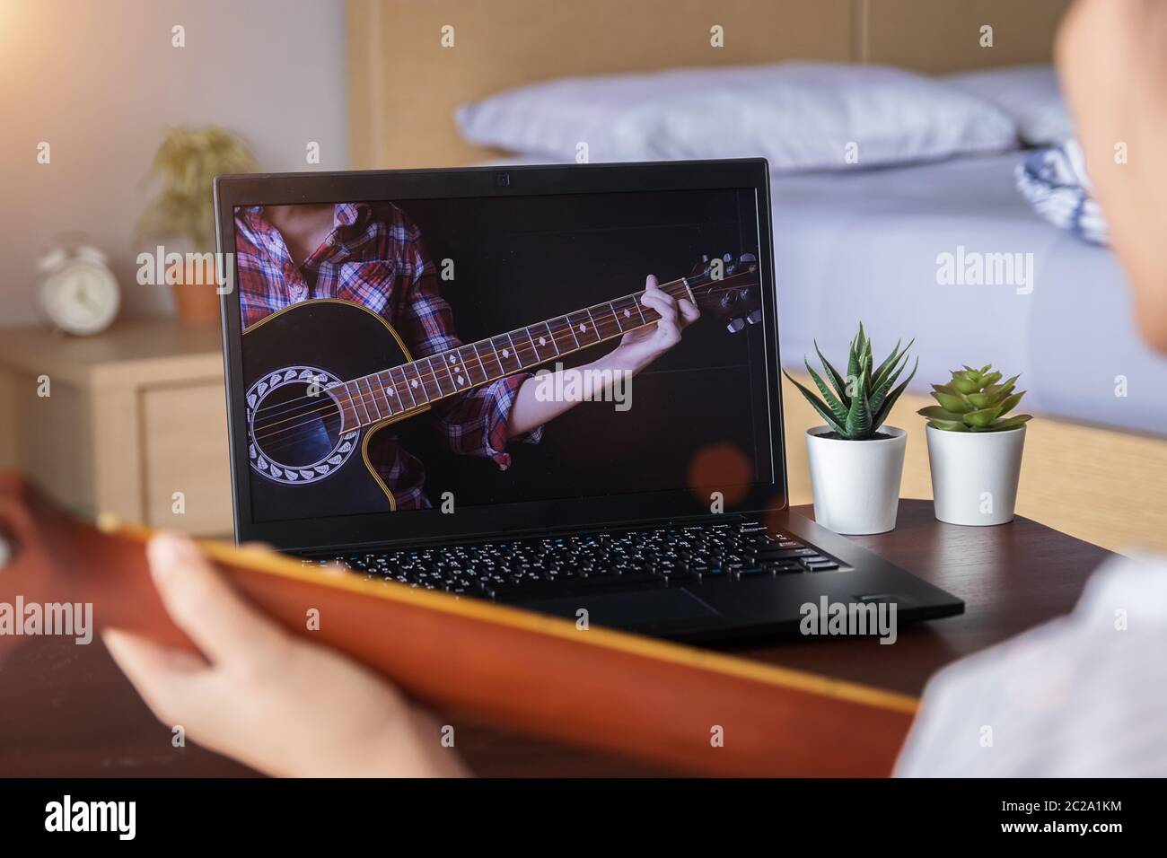 music academy online lesson concept. teenage spend their free time doing interesting activity at home by learning to play guitar chord from website Stock Photo