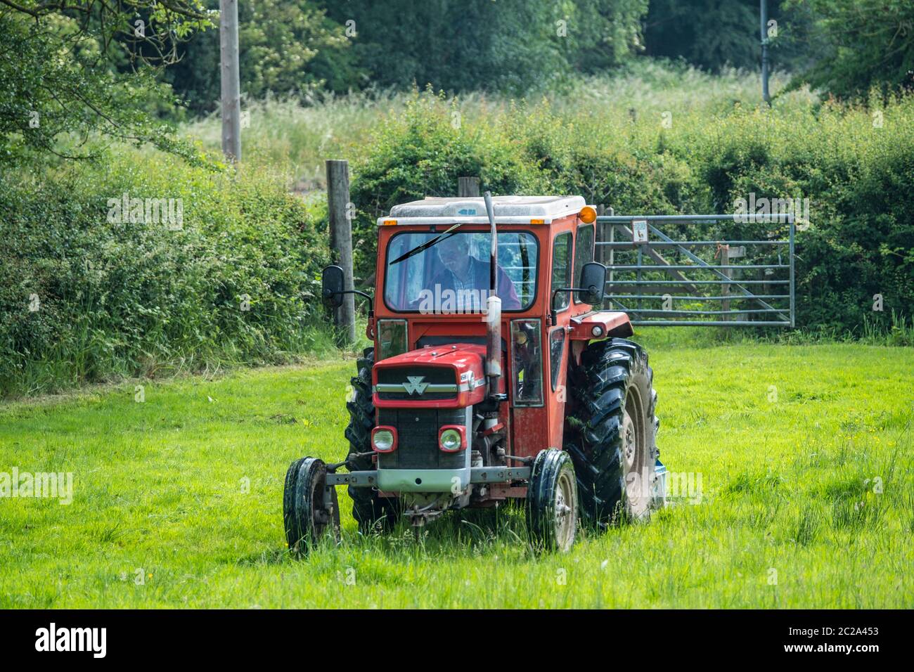 A Massey Ferguson 135 tractor and topper. Stock Photo