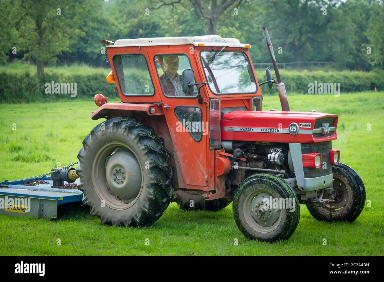 A Massey Ferguson 135 tractor and topper. Stock Photo