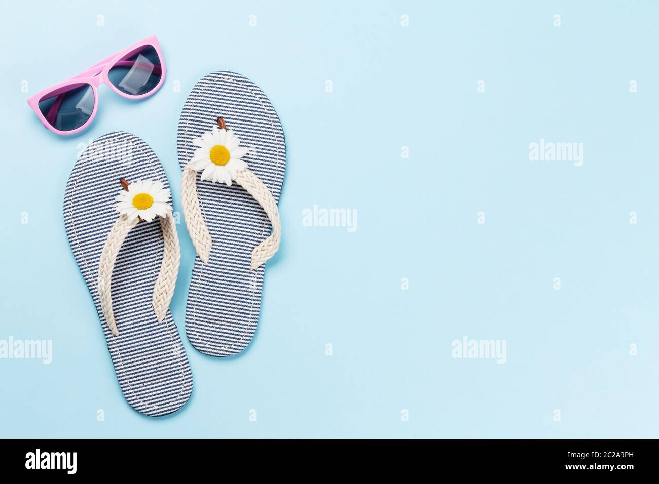 Beach flip flops with flowers and sunglasses on blue background. Summer ...