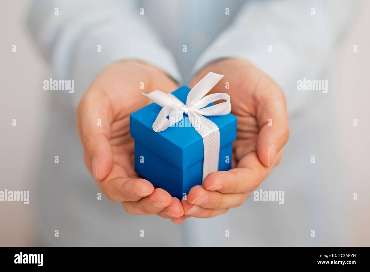 Small blue present box in hands Stock Photo
