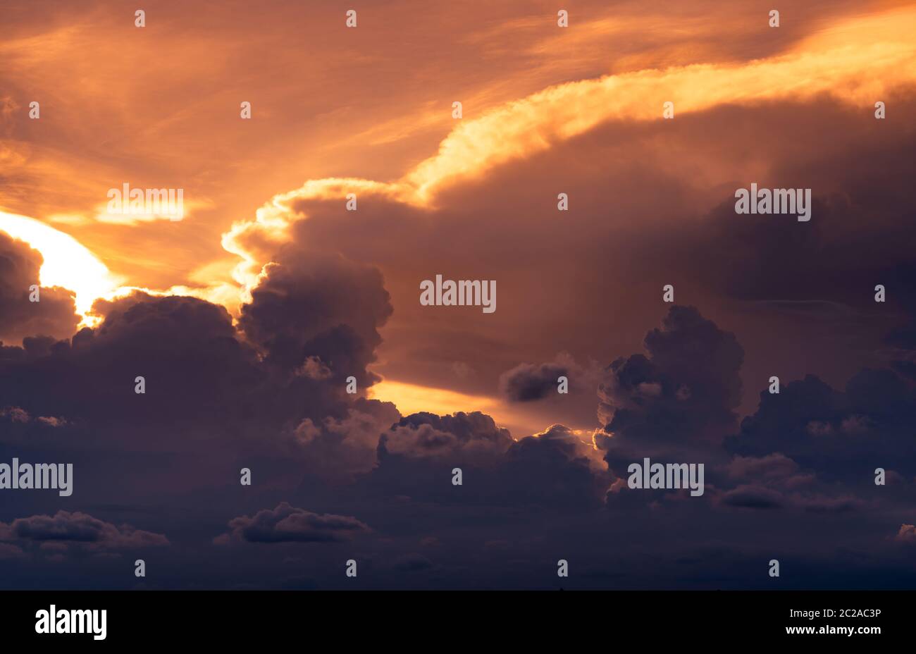 Sunset sky. Golden light shine in layers of clouds. Fluffy clouds at dusk. Twilight sky. God light. Cloudscape. Beauty in nature. Art picture of sky Stock Photo