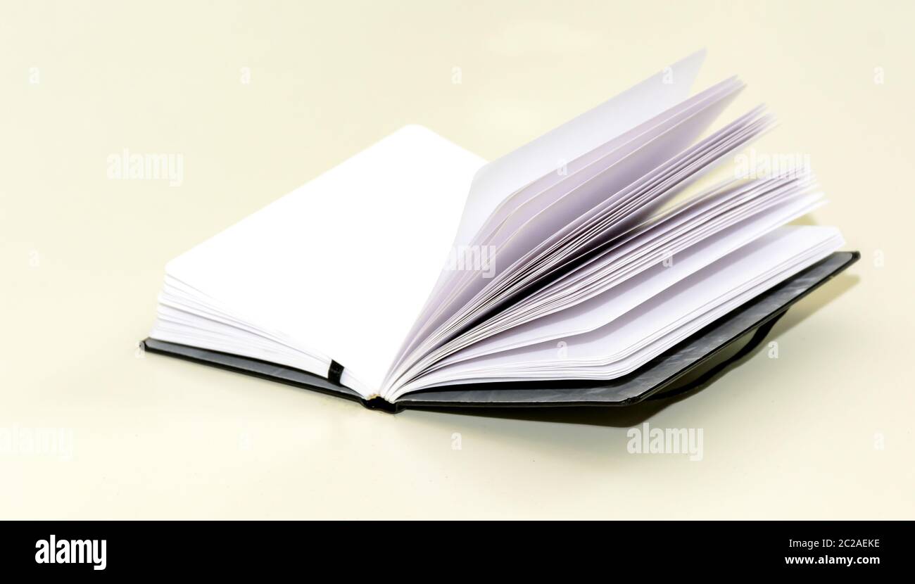 open hardcover notebook on a white table. Stock Photo