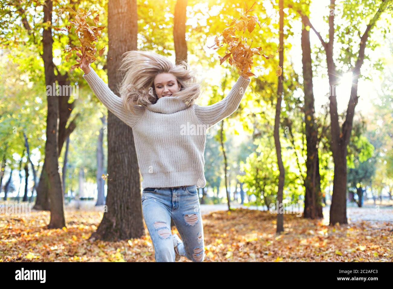 Happy blond girl posing in autumn park on yellow trees background Stock ...