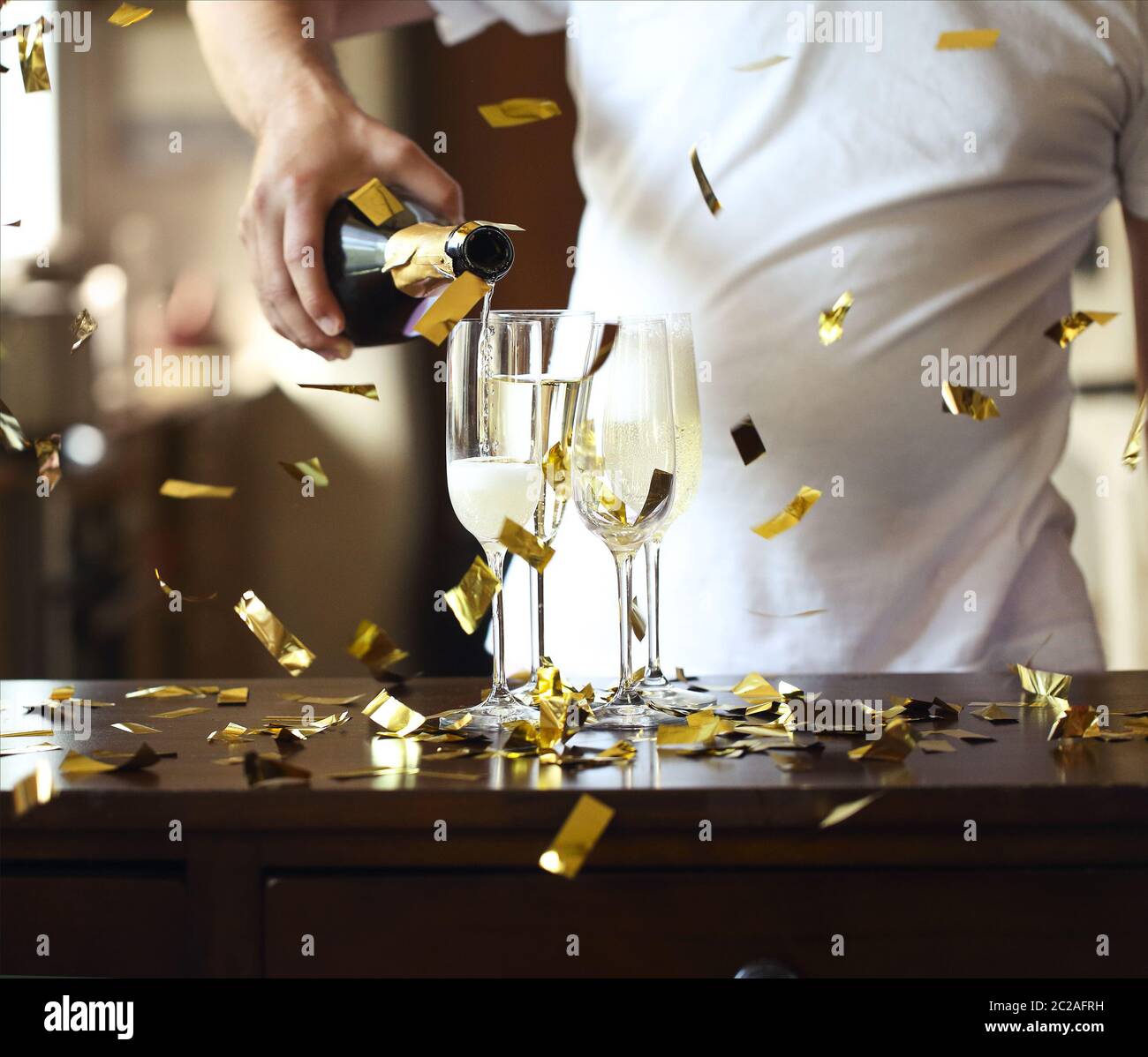 Champagne Flutes In Golden Sparkle Background with golden confetti. Man