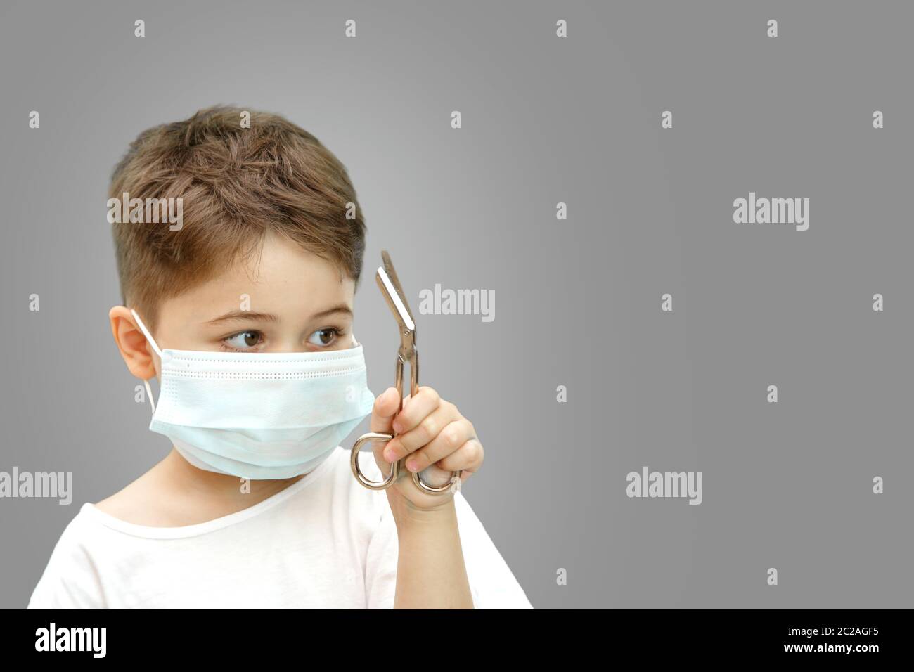 little Caucasian boy in a medical mask on an isolated background ...