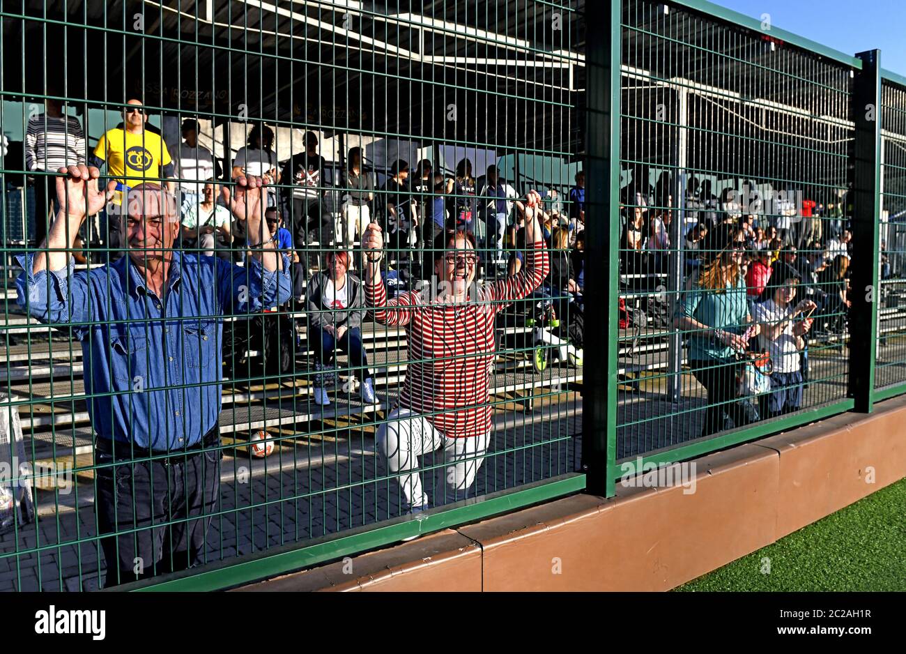 Parents following and supporting, a kids soccer match on tribune, in Milan. Stock Photo