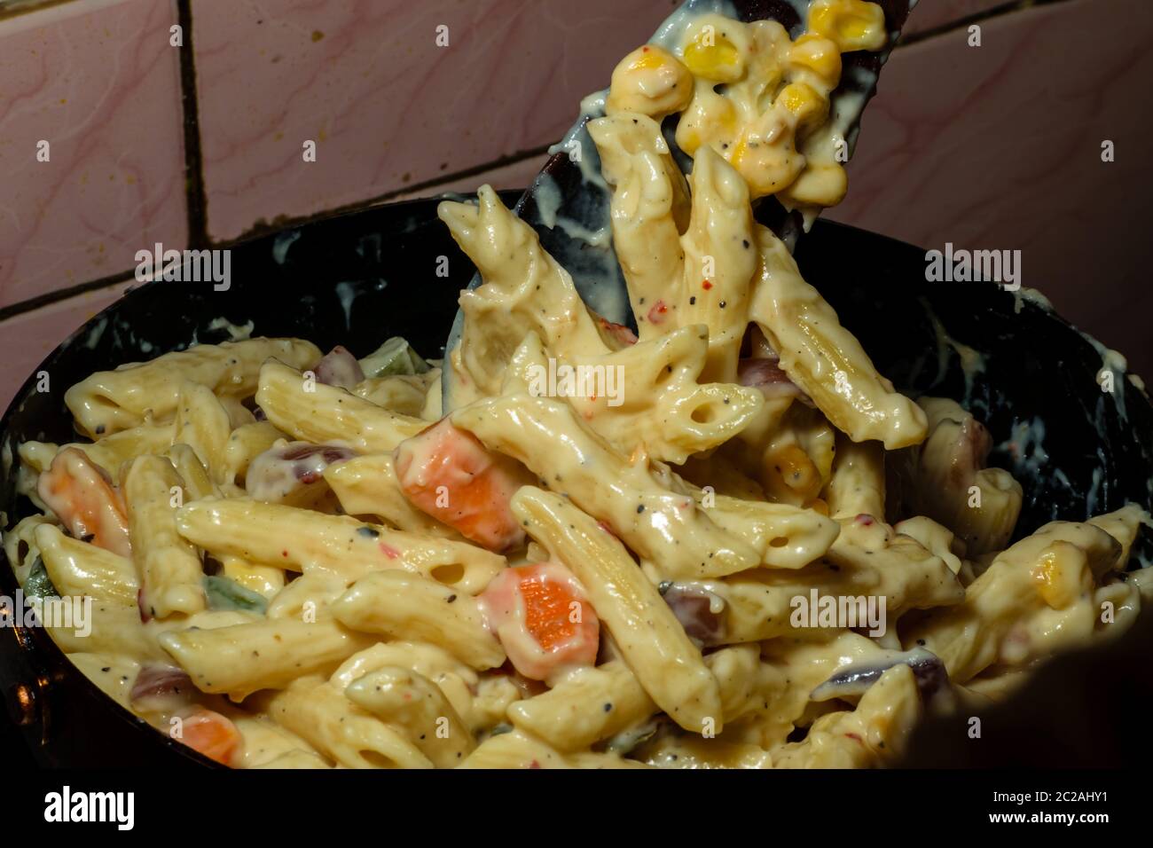 Pasta with white sauce and cheese being cooked at home Stock Photo Alamy
