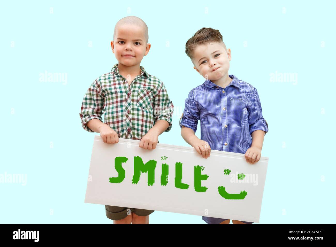 two boys holding a sign that says smile Stock Photo - Alamy
