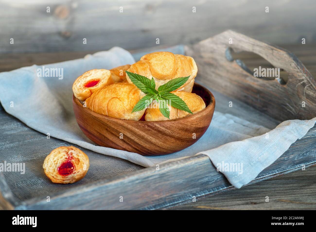 Croissants on a wooden tray. The concept of a wholesome breakfast. Stock Photo