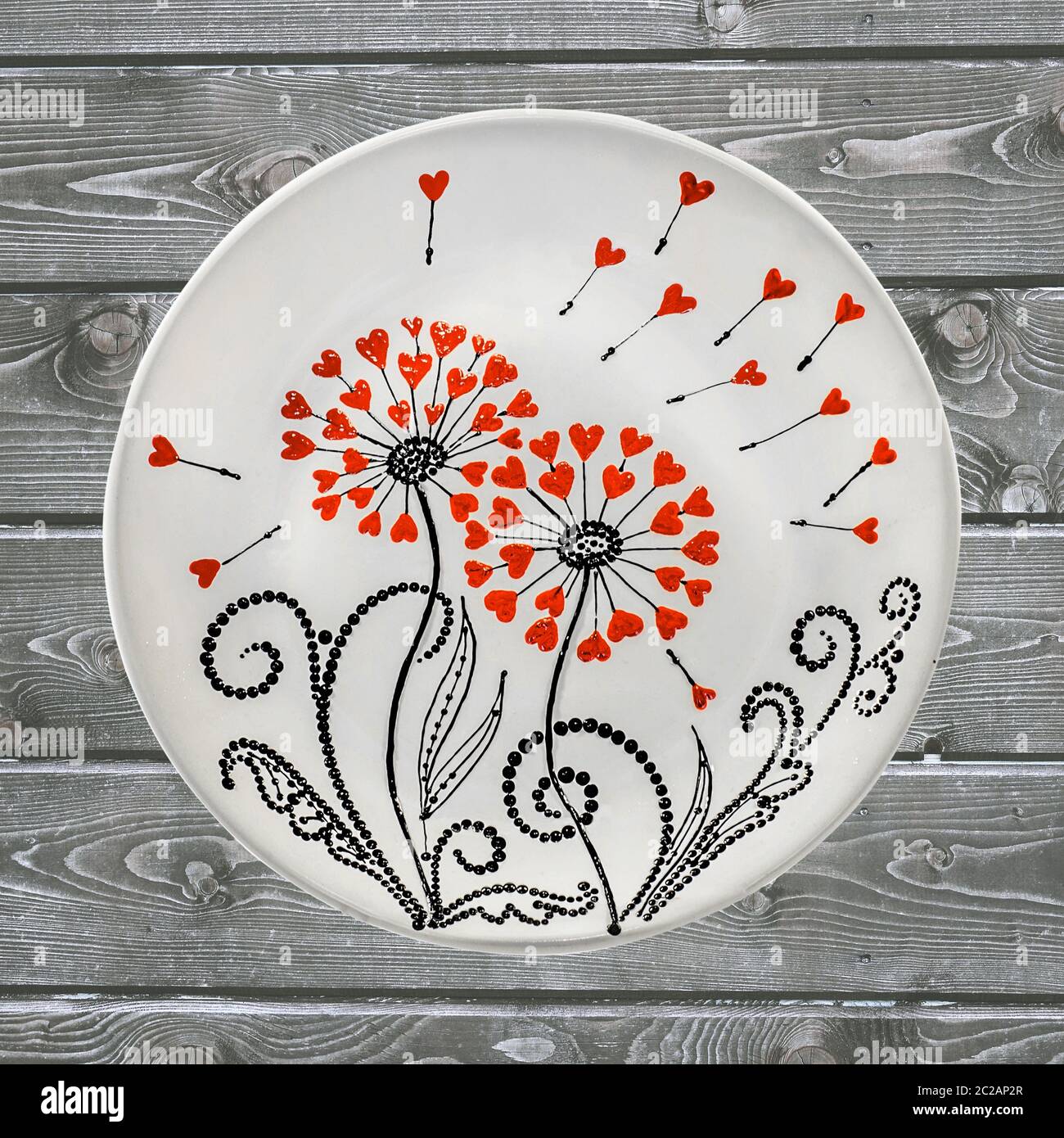 Decorative ceramic plate, hand painted with acrylic paints on a wooden background. A square photo closeup. Stock Photo