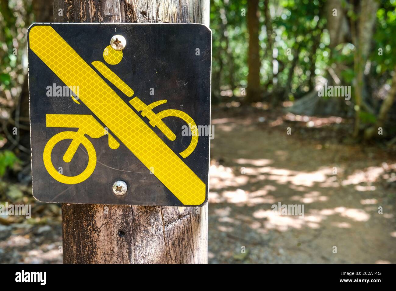 A sign saying no motorbike at the start of a forest trail Stock Photo