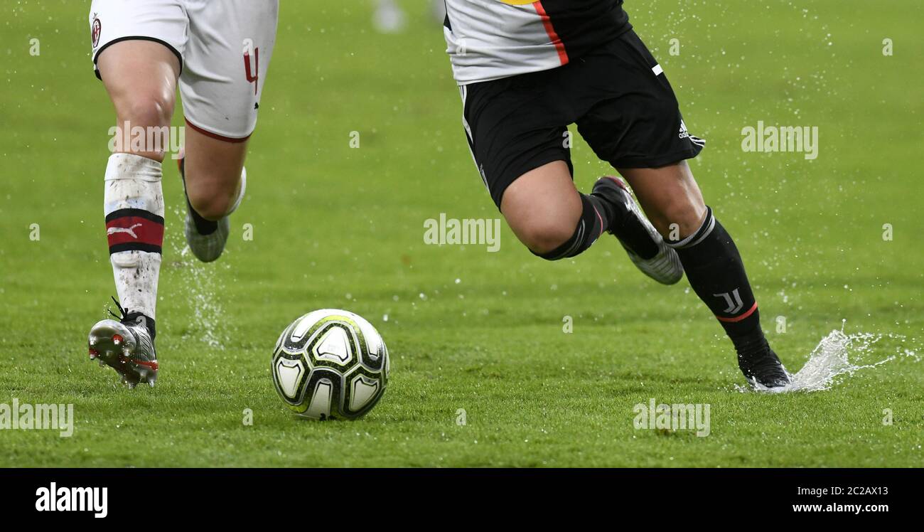 Close up legs of female soccer players action, on a wet green soccer field. Stock Photo