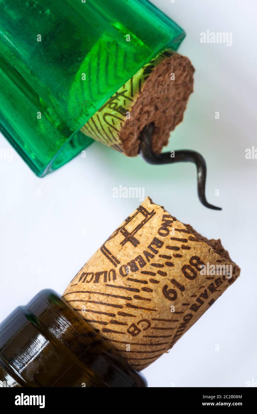 broken wine cork in wine bottle of white Rioja with corkscrew set on white background Stock Photo