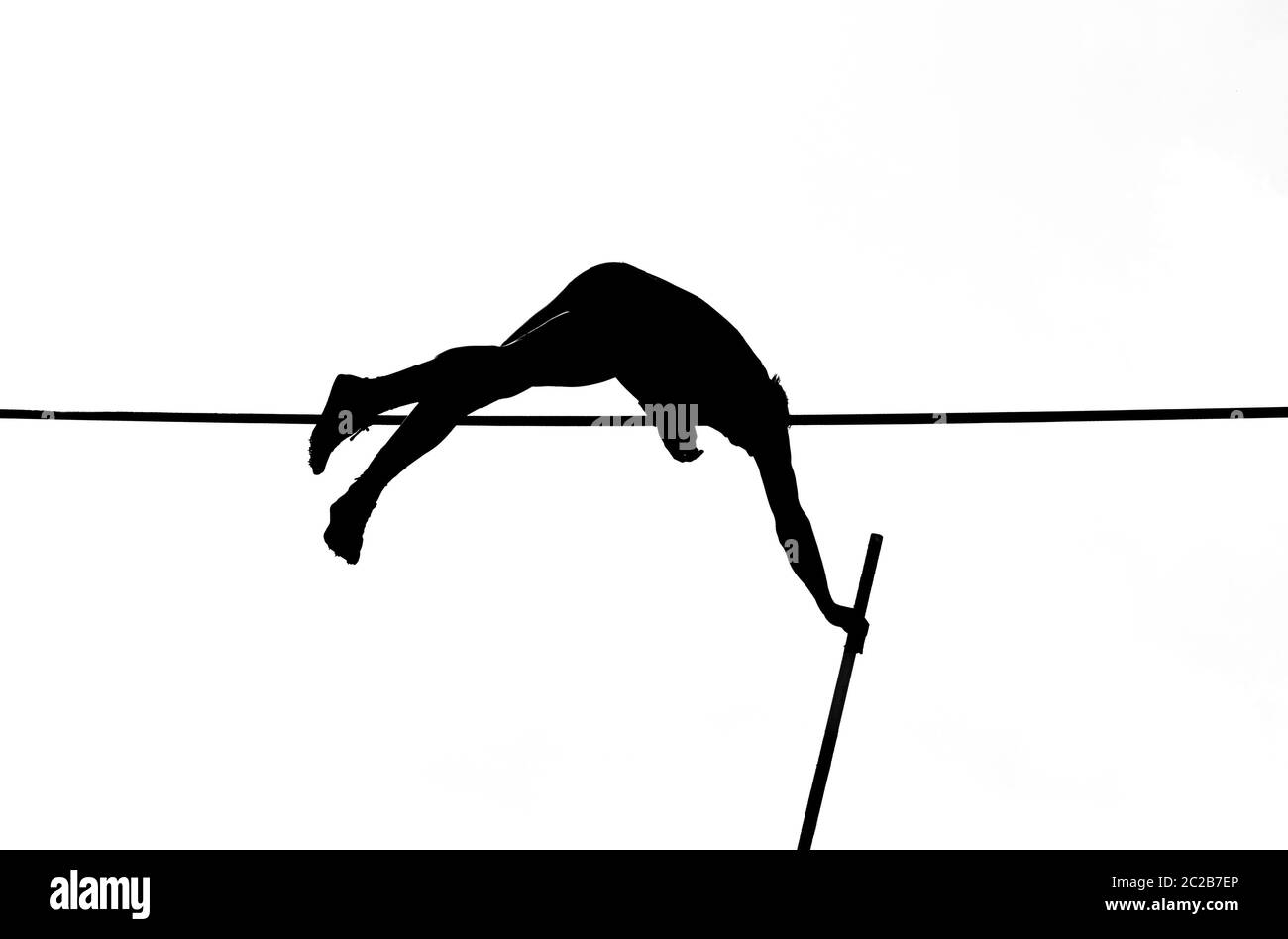 pole vault springer crossing the bar in black and white Stock Photo