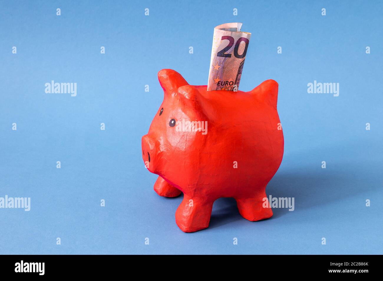 red papier mache piggy bank with 20 Euros Stock Photo