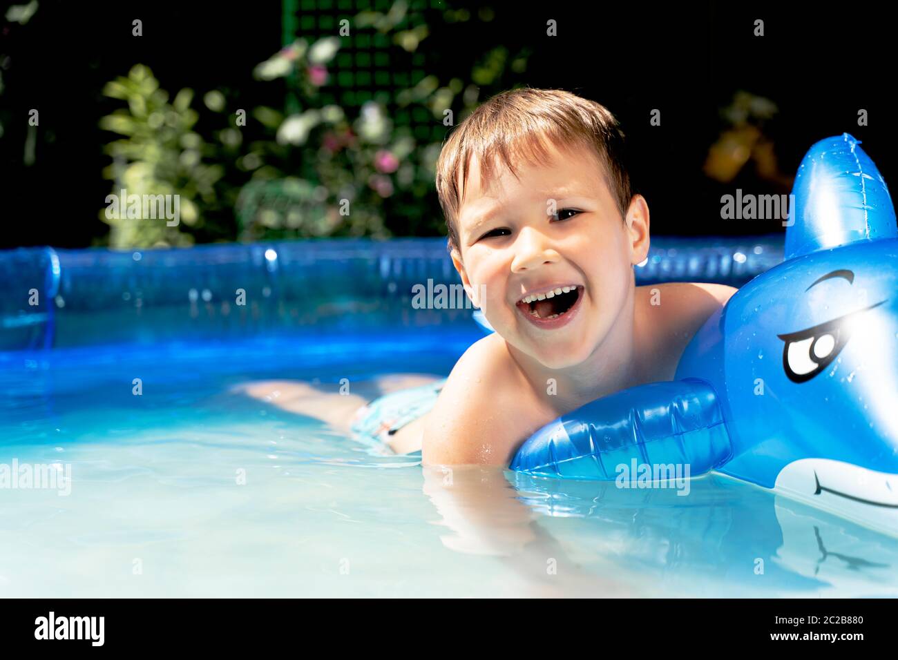Happy laughing toddler boy having fun in a swimming pool Stock Photo