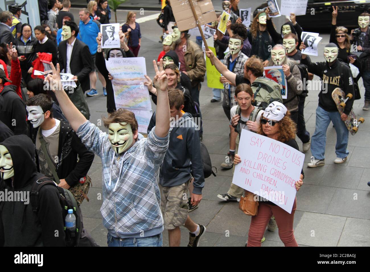 Protesters wearing anonymous masks march through Martin Place in Sydney ...