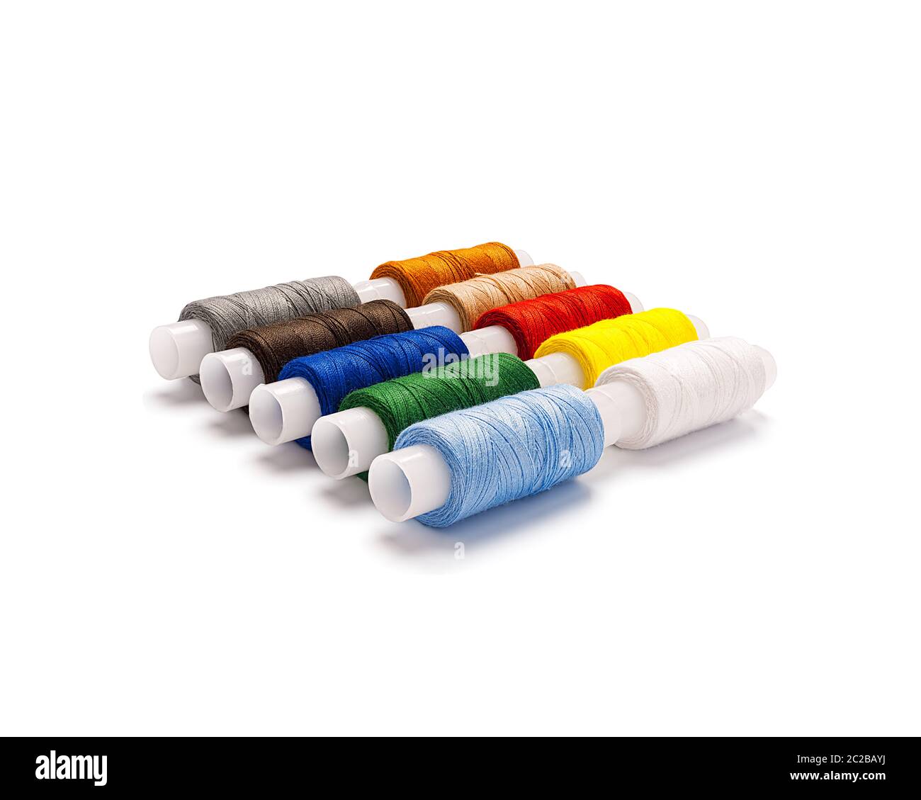 Set of multi-colored spools of cotton thread lying diagonally isolated ...