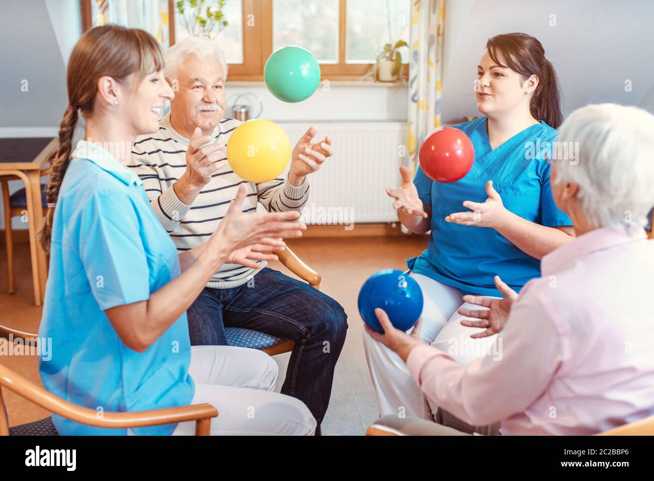 Group of seniors doing sport and gymnastics with balls in the pensioners home Stock Photo