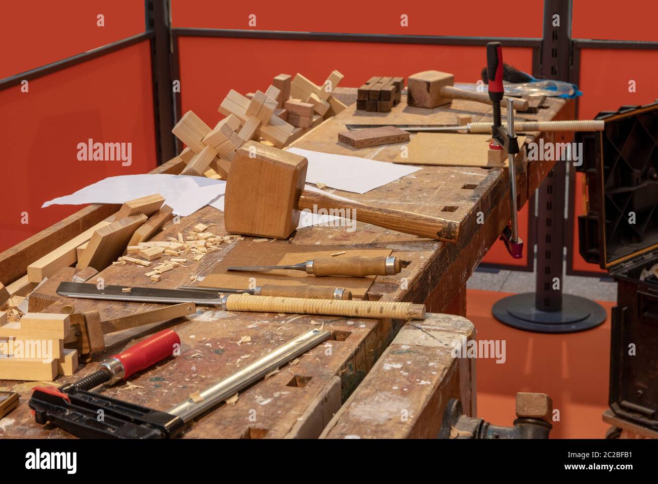 Carpentry workshop. A workbench in a carpentry with professional tools which the carpenter uses. Saws, screw clamps, mallet and wooden plane. Stock Photo