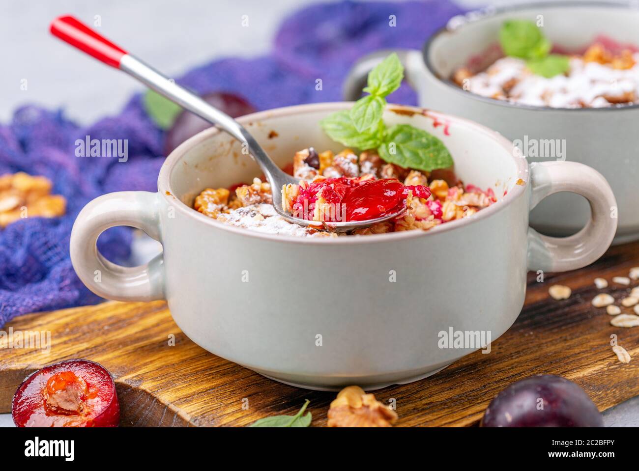 Red cherry plum crumble for breakfast. Stock Photo