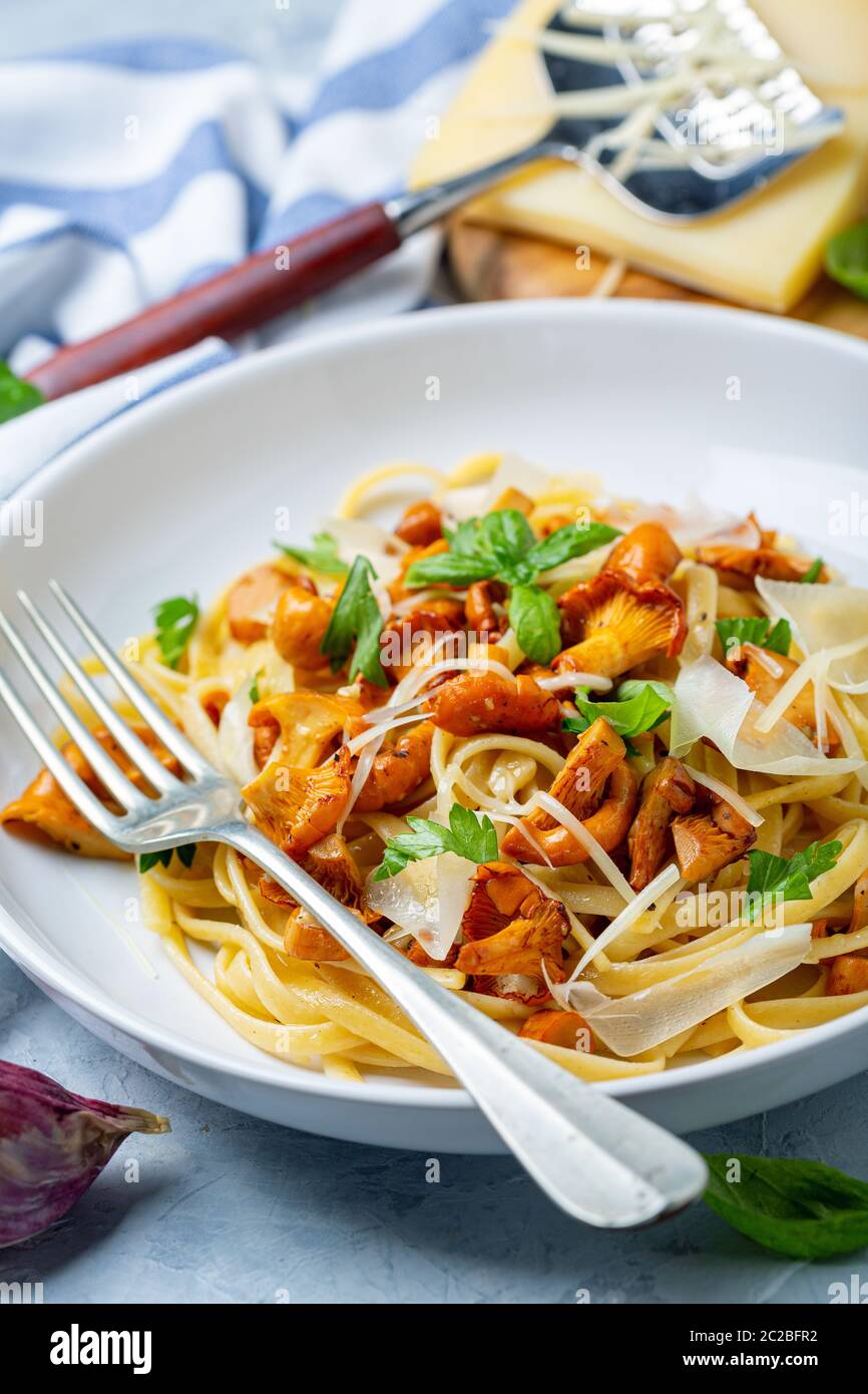 Pasta with wild chanterelles and parmesan. Stock Photo