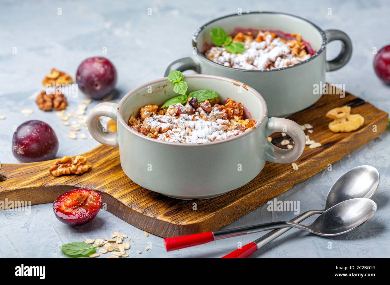 Crumble of red cherry plum, oatmeal and walnut. Stock Photo