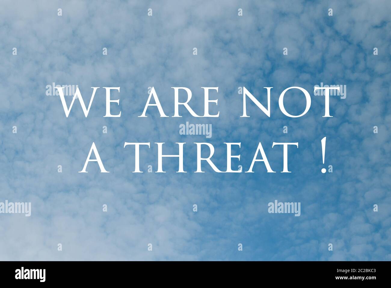 No Racism. Stop Racism. We are not a threat Sign with Dramatic Clouds and Sky. Stock Photo