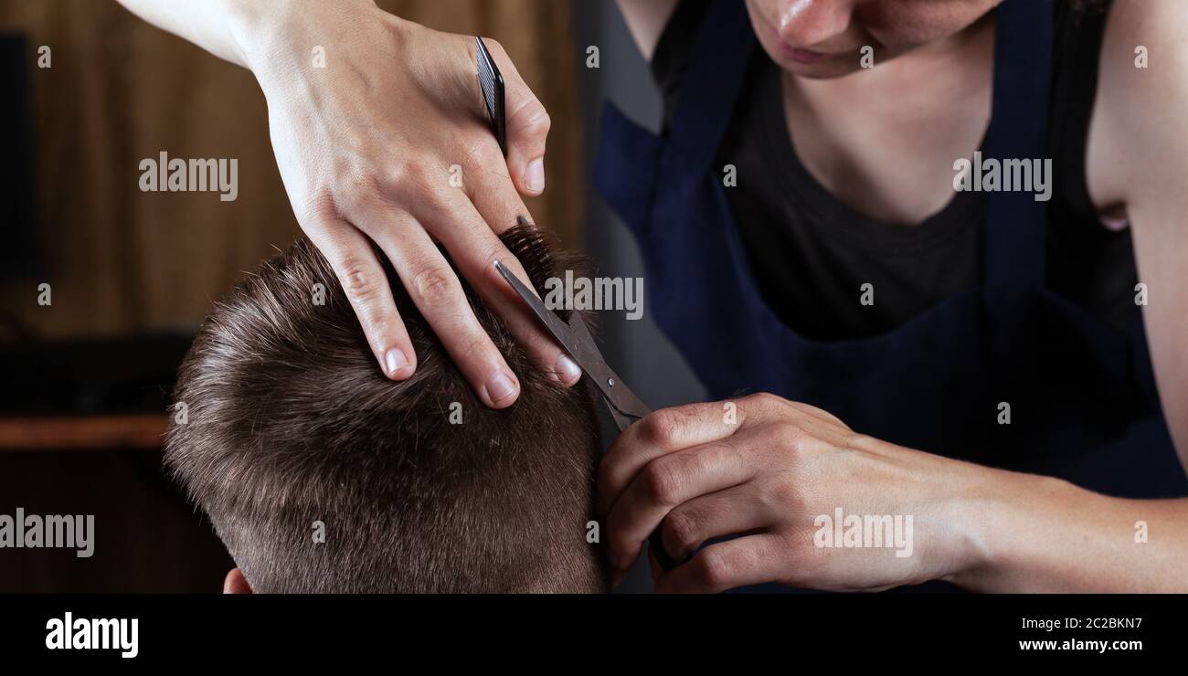men's haircut with scissors at home. barber shop works at home Stock