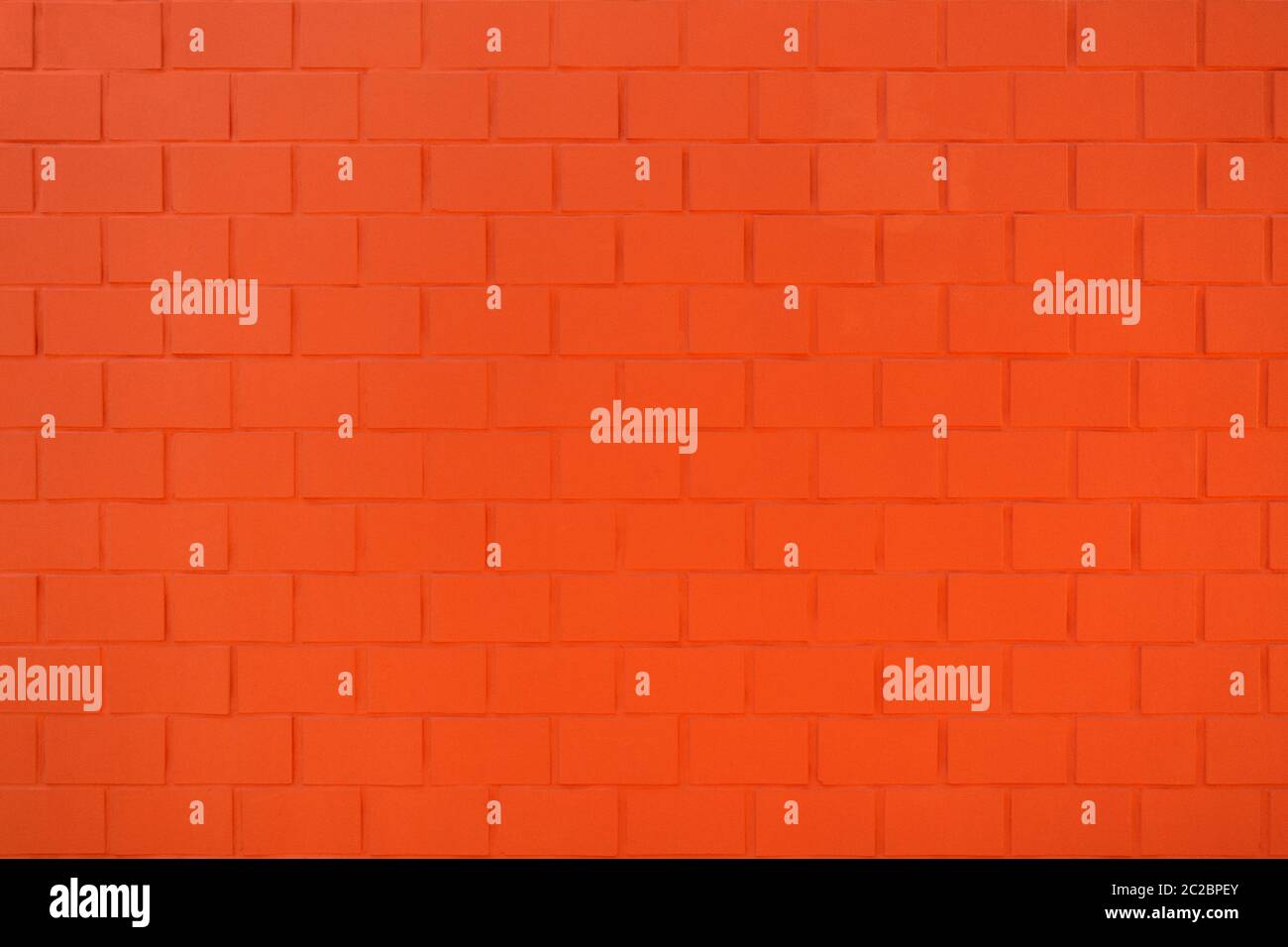 Detail of a brick wall painted in bright orange red Stock Photo