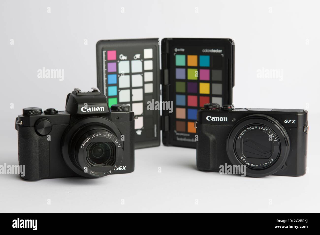 Milan, Italy - 17 June 2020: close up on Canon point and shoot cameras resting on white background. Stock Photo