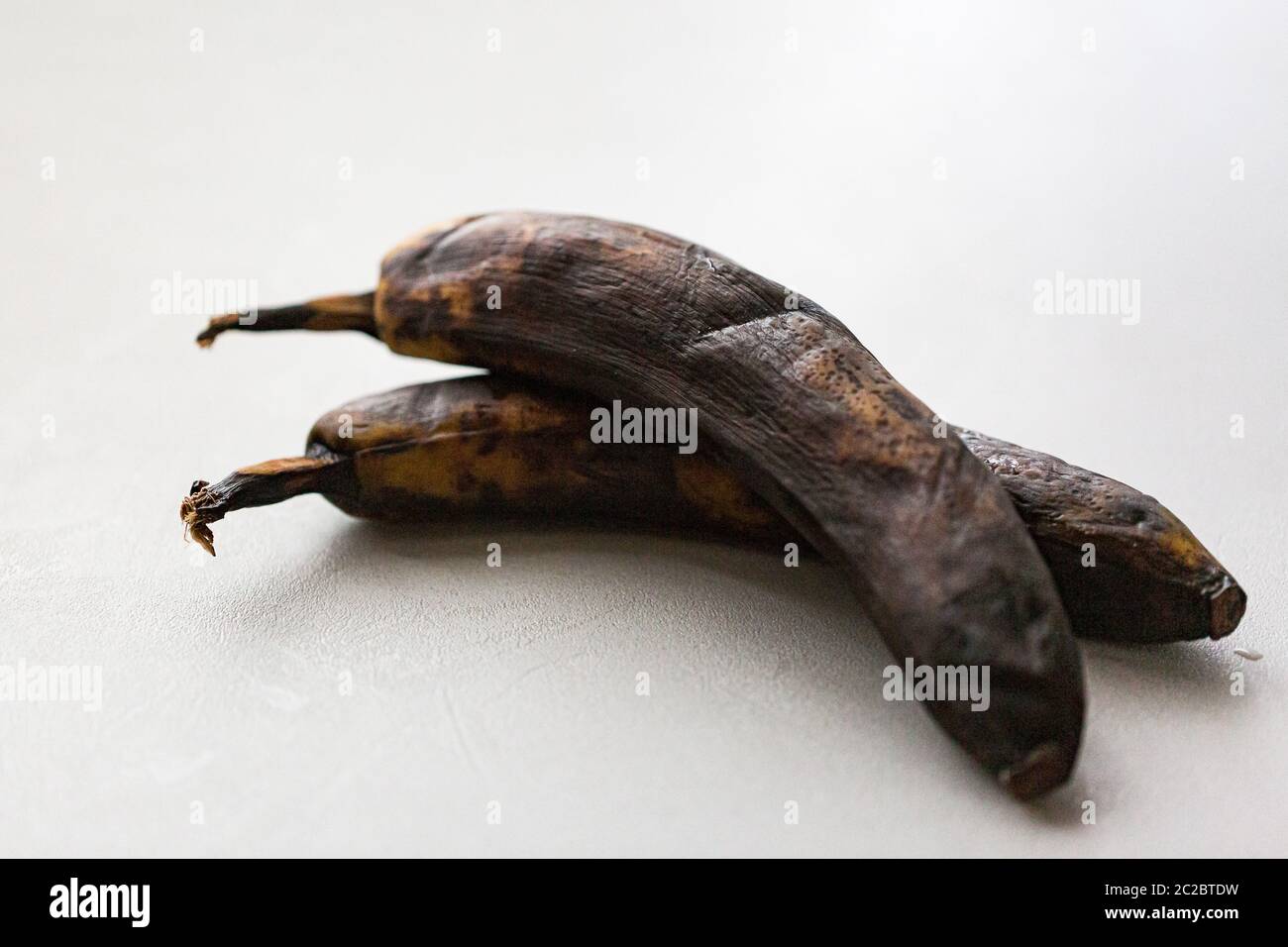 Dried unhealthy banana on white background. Trendy spoiled organic