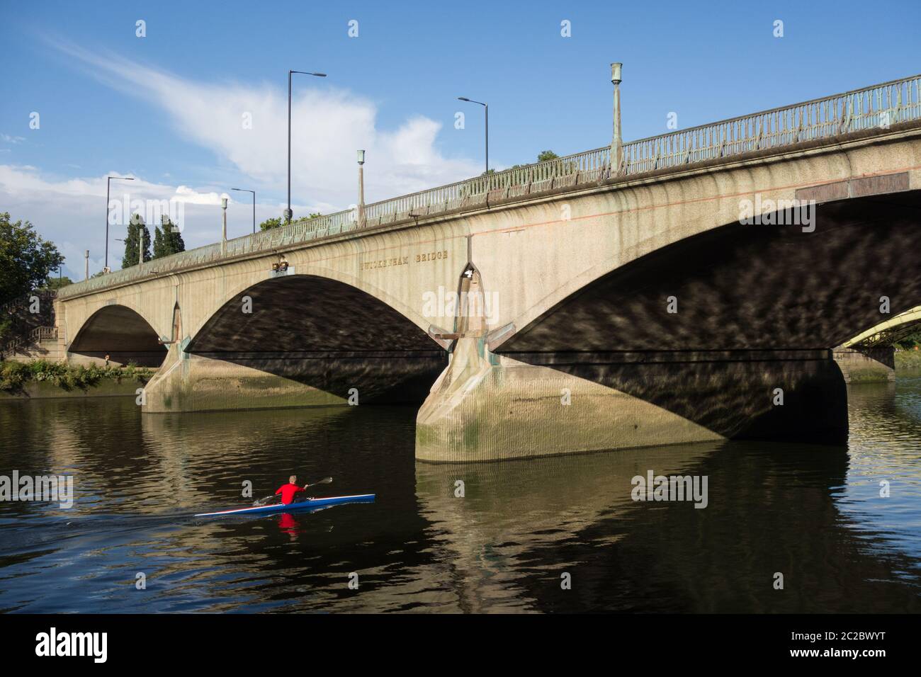 A man in his kayak approaching Maxwell Ayrton's Twickenham Bridge on the River Thames, London, UK Stock Photo