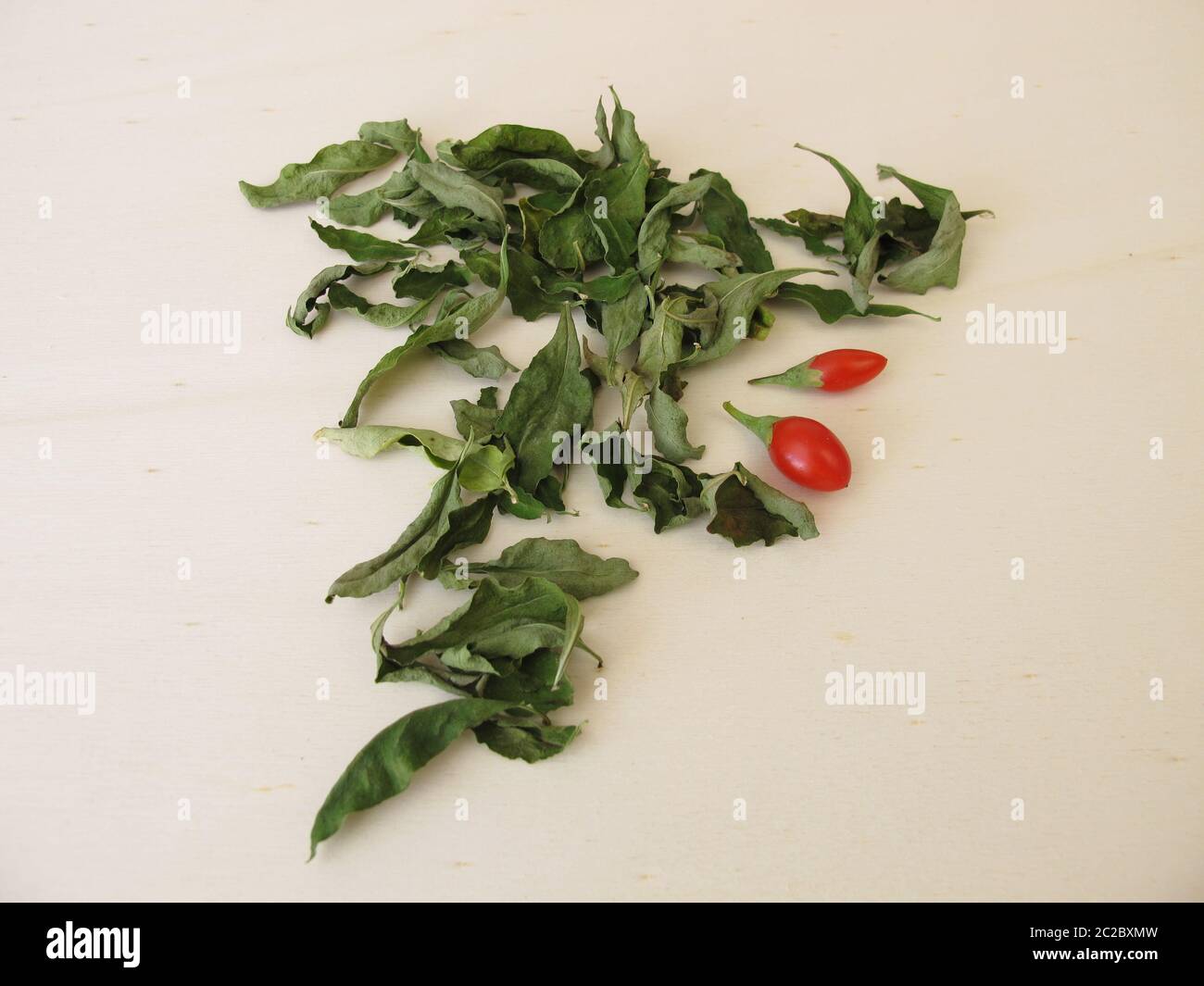 Dried goji leaves on a wooden board Stock Photo