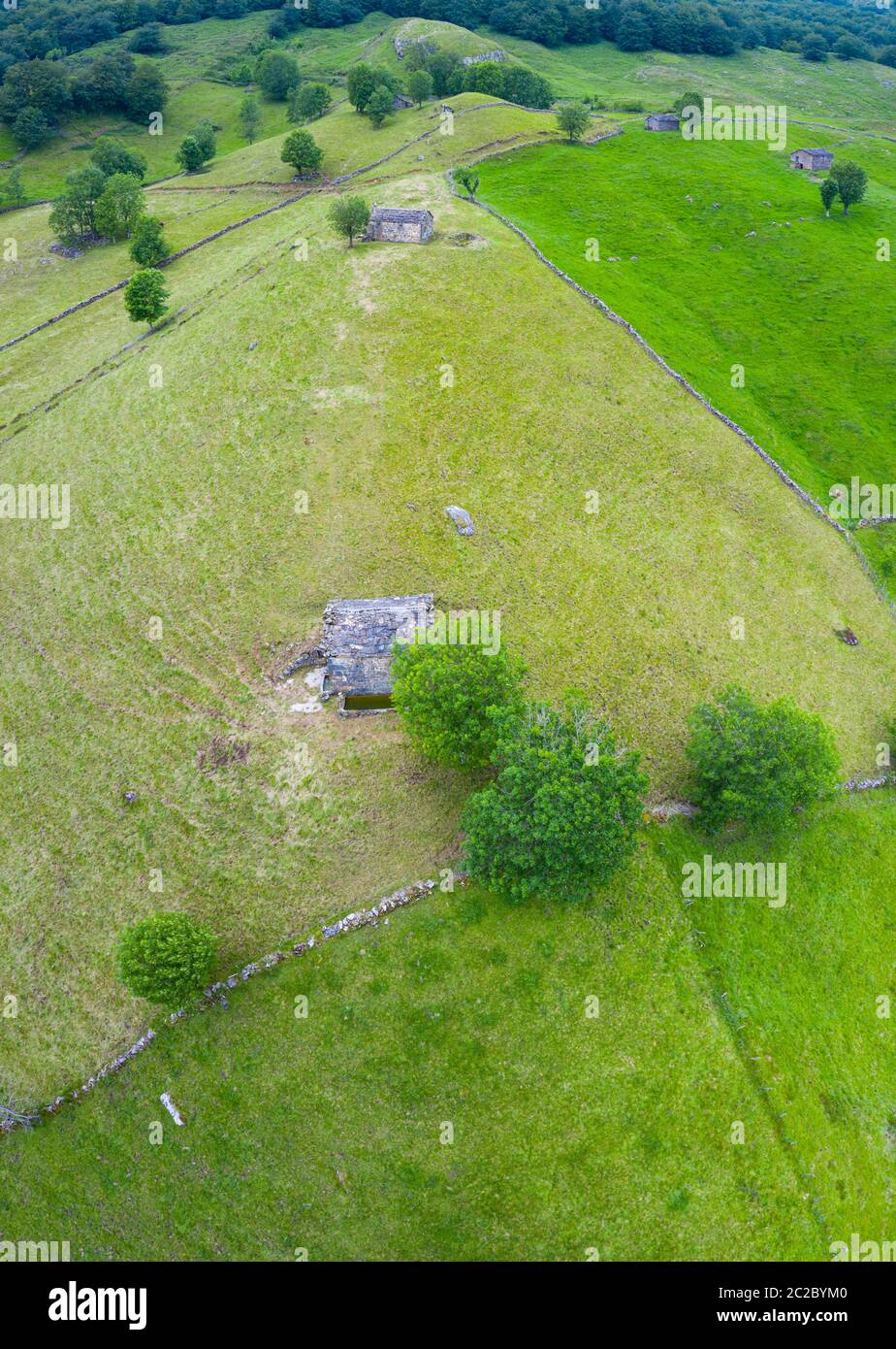 Aerial view with a drone of the spring landscape of pasiegas cabins and meadows in Miera Valley in Autonomous Community of Cantabria. Spain, Europe Stock Photo